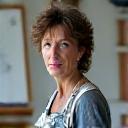 Portrait d'une artiste peintre dans son atelier, souriante.